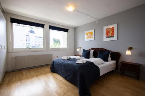 1 dormitorio con 1 cama y 2 ventanas en Søpark Apartments, en Maribo