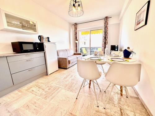 une cuisine et une salle à manger avec une table et des chaises dans l'établissement ApartHotel Riviera - Terrasse des Bougainvillees - 100m Promenade des Anglais, à Nice