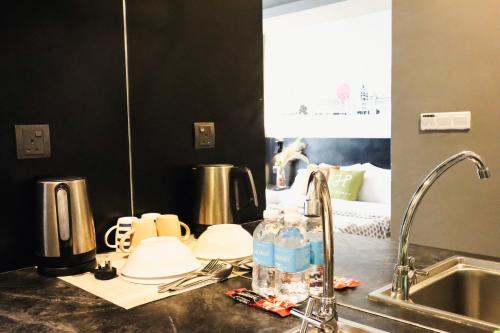 a kitchen counter top with a sink and a sink at Homesuite' Home at Aeropod SOVO in Kota Kinabalu