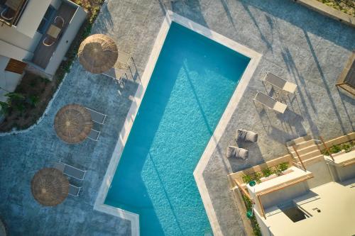 an overhead view of a swimming pool with chaise lounges at Villaggio Mare Suites in Kalamaki Chanion