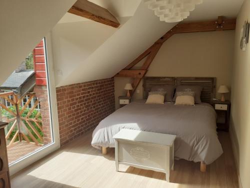 a bedroom with a bed and a large window at Les Gîtes du Château de Maltot in Saint-Ouen-du-Breuil