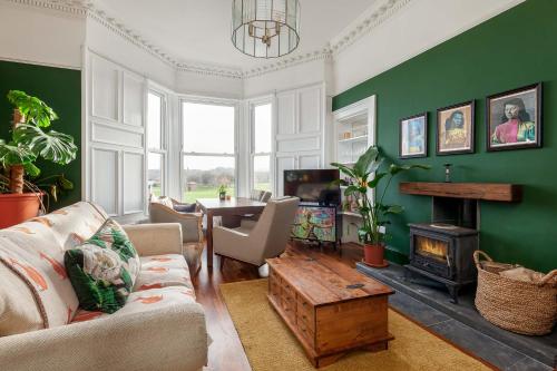 a living room with a couch and a fireplace at Stylish Victorian Apartment's close to the Botanical gardens, Free parking! in Edinburgh