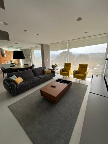a living room with a black couch and yellow chairs at Tres Prismas Exclusive in Sarria