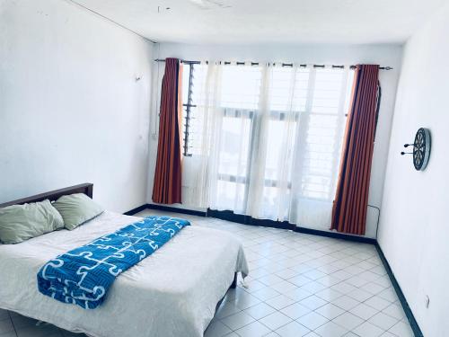 a bedroom with a bed and a large window at Nyali Casa Beach Bliss in Mombasa