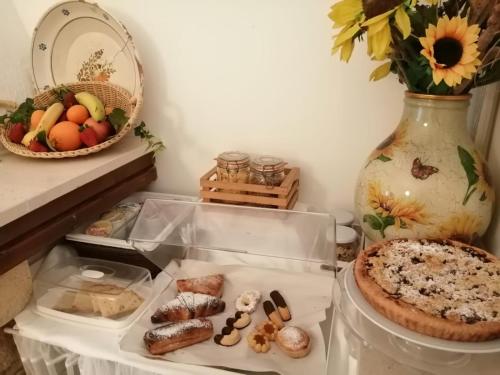 a table with a plate of food and a vase at B&B Villa Nonna Maria in Castellana Grotte