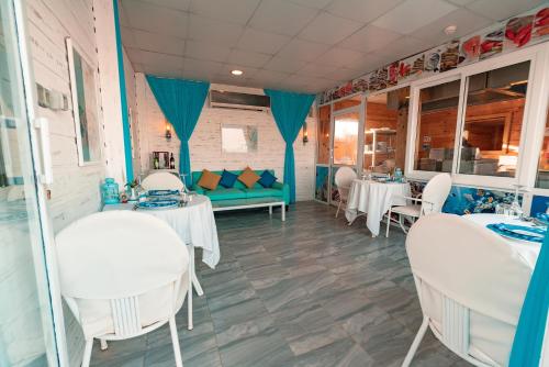 a dining room with white tables and chairs at Labranda Royal Makadi in Hurghada