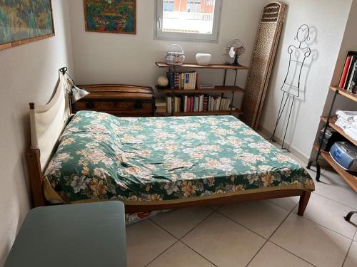 une chambre avec un lit avec une couette fleurie dans l'établissement Appartement plein centre, à Antibes