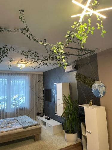 een slaapkamer met een bed en een plafond met planten bij Dom w górach z kominkiem i balią ogrodową Sielanka in Skomielna Czarna