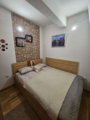 ヤホリナにあるApartman Viktor&Dariaのベッドとレンガの壁がある寝室