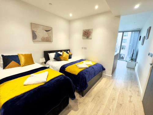 a bedroom with two beds with yellow and blue sheets at Tower Bridge, London Luxury Flat with Beautiful Garden Views in London