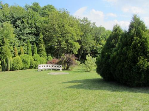 a park bench sitting in the middle of a field at Willa w Ogrodzie in Sandomierz