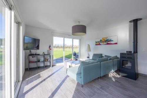 sala de estar con sofá azul y TV en Les Vignets comfortable holiday home, en Sainte-Honorine-des-Pertes