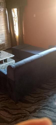 Bett in einem Zimmer mit Sofa und Fenster in der Unterkunft G4 property venture in Ijoko