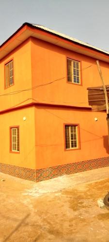 un edificio anaranjado con ventanas laterales en G4 property venture, en Ijoko
