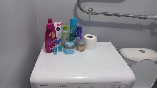 a bathroom with a toilet with cleaning products on it at Коктем 16 in Taldykorgan