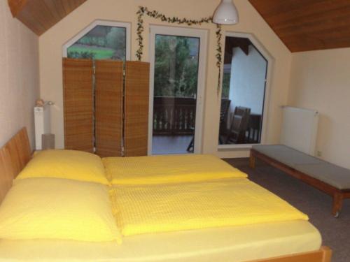 ein Schlafzimmer mit einem Bett mit gelber Bettwäsche in der Unterkunft Ferienwohnung Walter - Friedrichroda in Friedrichroda