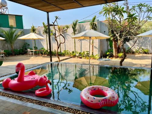 a swimming pool with two rubber ducks in the water at Hoàng Khang Hotel in Buôn Kô Sir