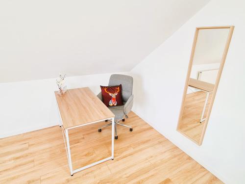 a desk and a chair in a room with a mirror at Apartment Nähe Airbus in Manching