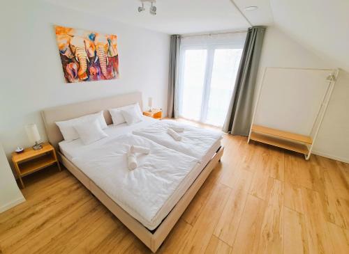 een slaapkamer met een groot bed met witte lakens bij Apartment Nähe Airbus in Manching