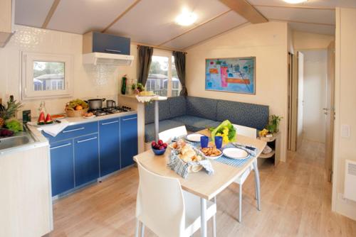 a kitchen with a table and a kitchen with blue cabinets at Casa mobile - Bella Austria**** in Sankt Peter am Kammersberg
