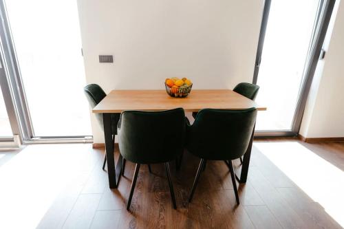 einen Tisch mit Stühlen und eine Obstschale darauf in der Unterkunft Apartman Marinela in Belišće