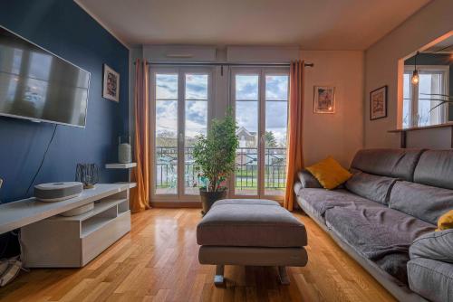 a living room with a couch and a large window at Apart' Minnie - Disneyland Paris - 3 Bedrooms - Parking privé in Magny-le-Hongre