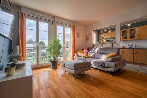 a living room with a couch and a table at Apart' Minnie - Disneyland Paris - 3 Bedrooms - Parking privé in Magny-le-Hongre