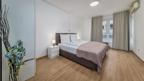 ein Schlafzimmer mit einem Bett und einem großen Fenster in der Unterkunft Deluxe City AS Apartment - FREE PARKING in Zagreb