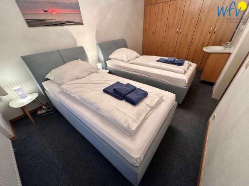 two beds in a hospital room with towels on them at Dünenschlösschen - Ferienwohnung 34 in Wangerooge