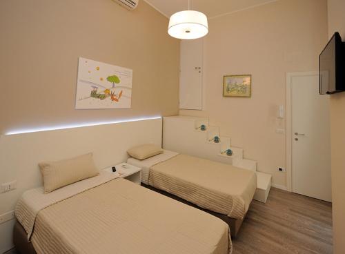 グラヴィーナ・イン・プーリアにあるIl Piccolo Principe B&Bのベッド2台とテレビが備わるホテルルームです。