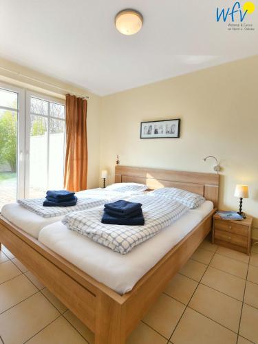 a bedroom with a large bed with blue towels on it at Villa Cila Ferienwohnung 5 in Wangerooge