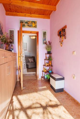 a kitchen with pink walls and a door to a room at Andreas Guest House in Gavalochori