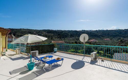 a balcony with a table and an umbrella at Andreas Guest House in Gavalochori