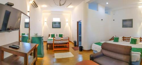a room with a bed and a table and a couch at Yala Golden Wild in Tissamaharama
