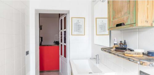 eine Küche mit einer Spüle und einem roten Kühlschrank in der Unterkunft Rosmini house in Novara