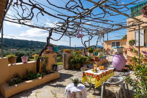 a patio with a table and chairs and plants at Andreas Guest House in Gavalochori