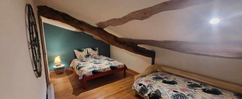 a bedroom with two beds in a room with a beam at La Boriette du Rougier in Montlaur