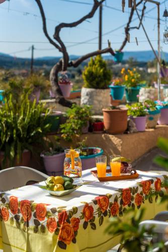 a table with a plate of fruit and glasses of orange juice at Andreas Guest House in Gavalochori