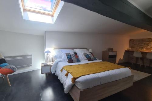 um quarto com uma cama grande e um cobertor amarelo em La casa cosy love, avec jacuzzi et sauna privés em Palau-del-Vidre