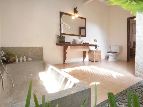 a bathroom with a sink and a toilet and a mirror at Ho Tram Beach Boutique Resort & Spa in Ho Tram