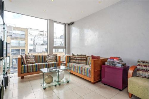 a living room with two couches and a table at Multi-Award Winning 7 Storey Home - Near Shoreditch in London