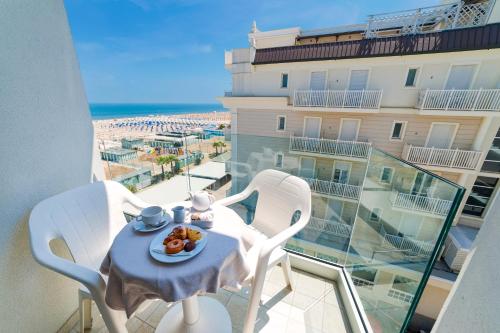 un tavolo con un piatto di cibo in cima a un balcone di Grand Meeting Hotel a Rimini