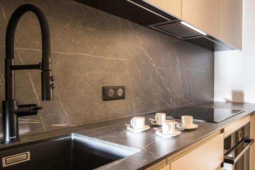 - une cuisine avec un évier et des tasses sur un comptoir dans l'établissement 5mn Monaco - Luxueux appartement - BT, à Beausoleil
