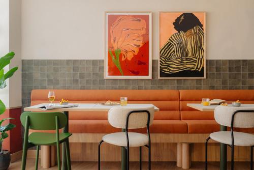 ein Restaurant mit zwei Tischen und zwei Gemälden an der Wand in der Unterkunft Leonardo Hotel Hengelo City Center in Hengelo