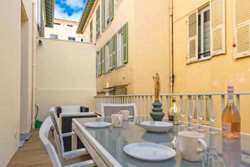 une table en verre et des chaises sur un balcon dans l'établissement 5mn Monaco - Luxueux appartement - BT, à Beausoleil