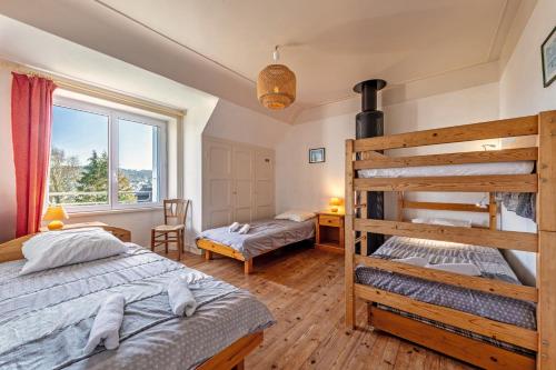 a bedroom with two bunk beds and a window at Maison 15pers 300m de la plage in Crozon