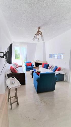 a living room with several couches and a table at Gentle Breeze apartment in Kamena Vourla
