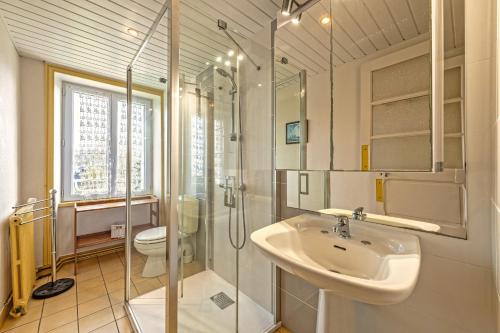 a bathroom with a sink and a shower and a toilet at Maison 15pers 300m de la plage in Crozon