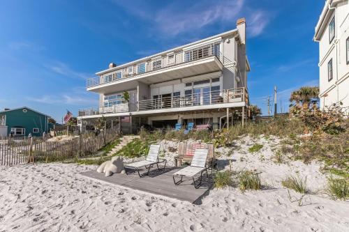 a house on the beach with two chairs and a dog at Breathtaking Beach Front House home in St. Augustine