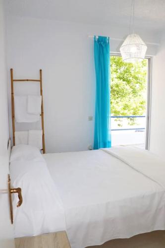 a bedroom with two white beds and a window at Gentle Breeze apartment in Kamena Vourla